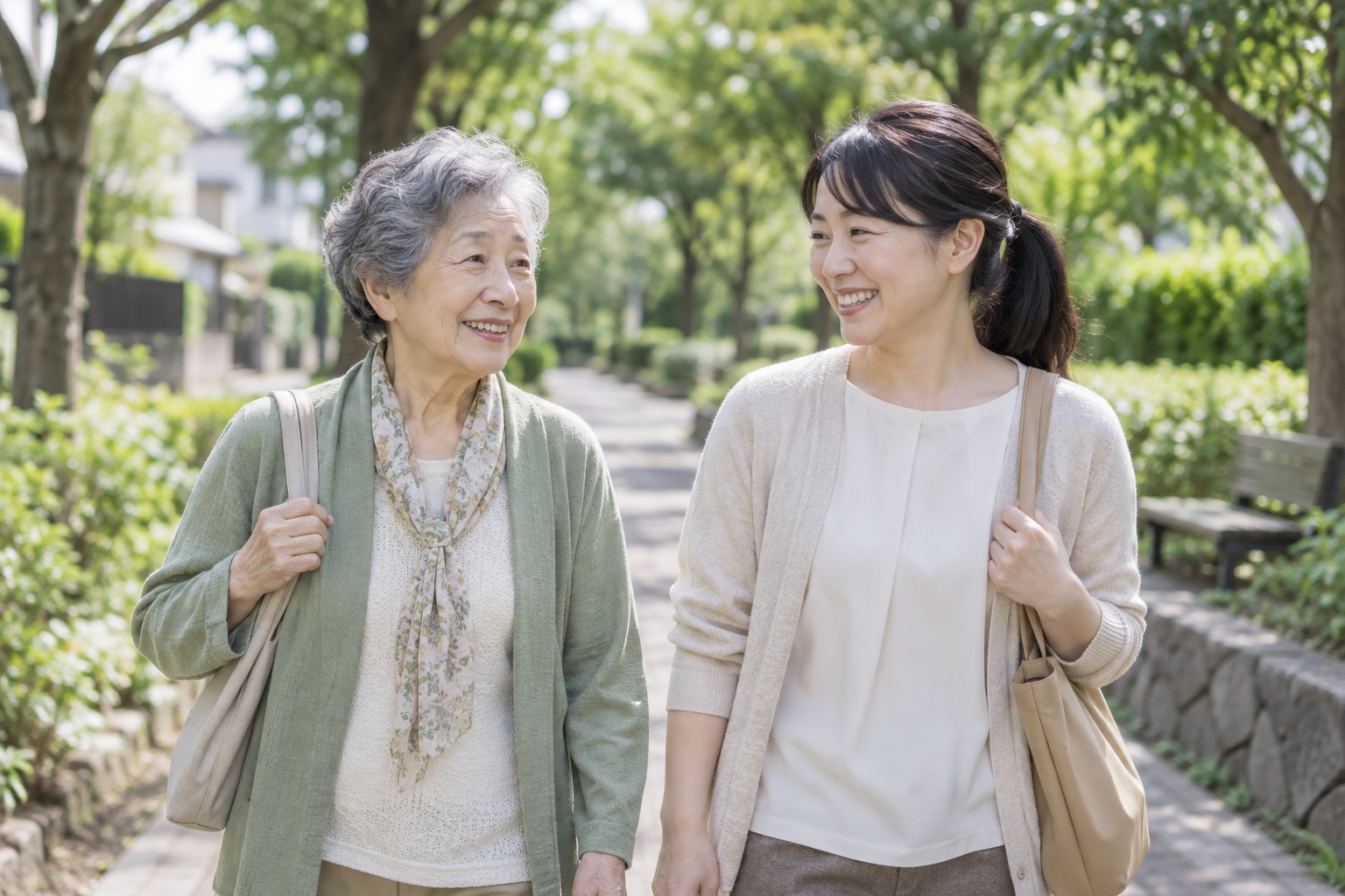 緑の並木道を歩く高齢の女性と生活支援員のイメージ